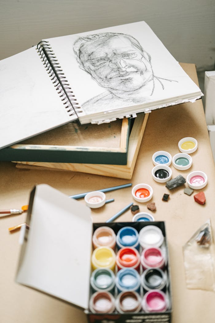 Creativity flows in an artistic workspace featuring a sketchbook and vibrant paints.